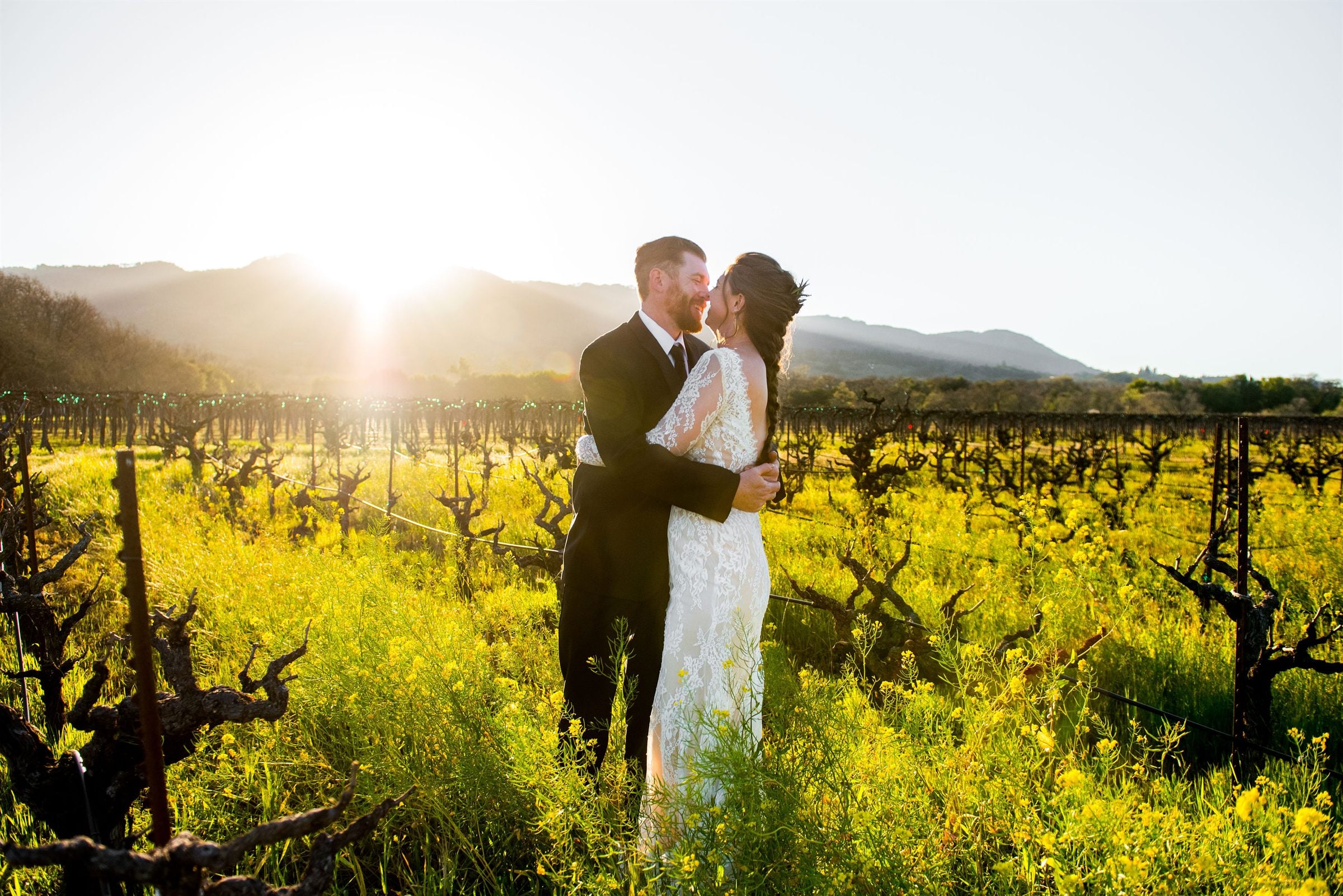 A couple embraces at golden hour in a Wine Country vineyard